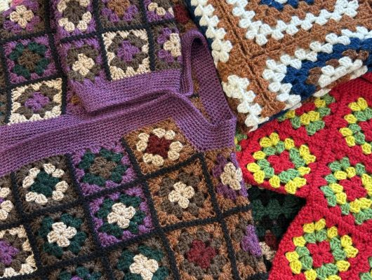 Colorful crocheted granny square blankets and pieces.