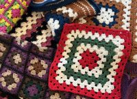 A colorful collection of crocheted granny squares in various patterns and colors.